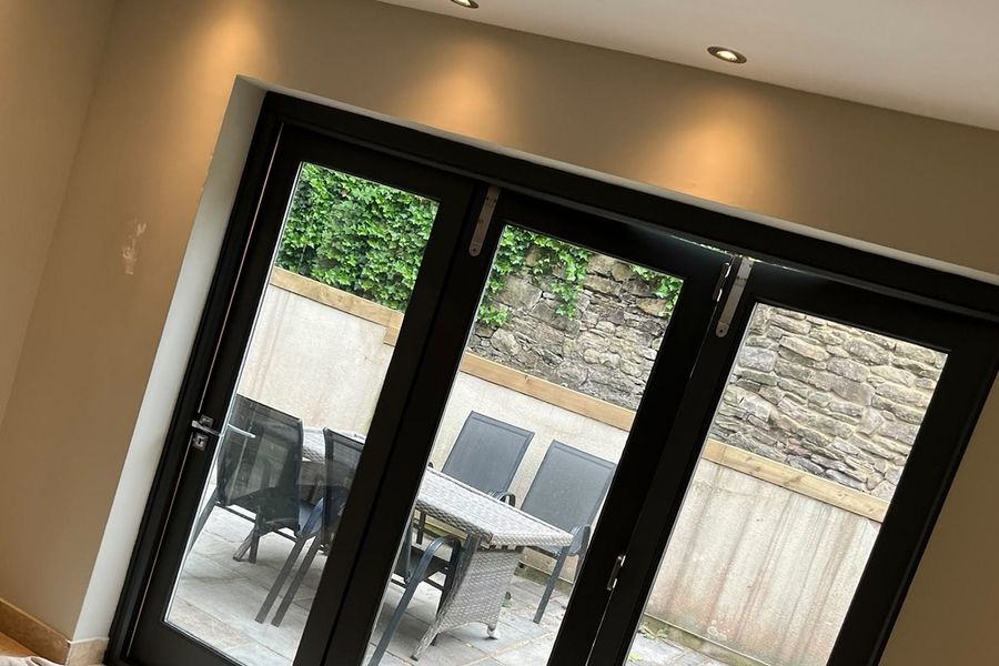 Garden room with bifold doors, walls in warm stone